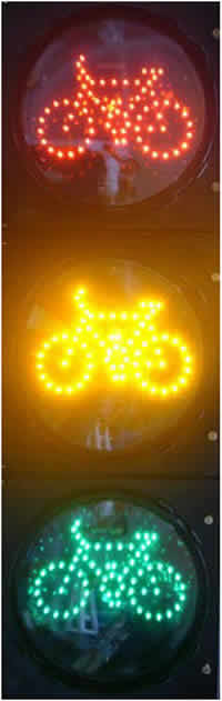 Figure 4 is a close-up photograph of an LED bike signal head with a red bike indication, a yellow bike indication, and a green bike indication from top to bottom respectively.