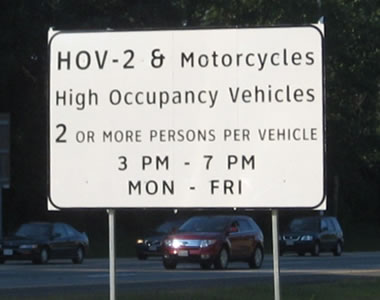 Rectangular regulatory sign for high-occupancy vehicles. The legend is displayed in upper- and lower-case letters of the alternative alphabet.