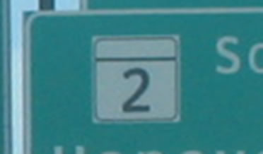 A portion of a sign with a State marker is shown using the alternative letter style to display the numeral.