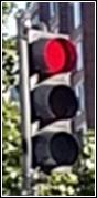 Shows a three-section vehicular signal face with the circular red signal indication in the top section illuminated.