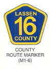 Guide Sign "COUNTY ROUTE MARKER (M1-6)" is shown as an upward-pointing blue pentagon, with a yellow border and legend. The word "LASSEN" above the large numerals "16" and the word "COUNTY" are shown on three lines. The sign is labeled "County Route Sign."