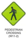 Pedestrian and Bicycle Sign "PEDESTRIAN CROSSING (W11-2)" is shown as a green with black borders and legends, diamond-shaped sign with a symbol of a left-facing walking person.