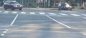 These two photos both show a crosswalk that is marked not only by a pair of white transverse lines that define the outside edges of the crosswalk, but also by a series of wide white longitudinal lines parallel to traffic flow between the transverse lines to make the crosswalk more visible to motorists.