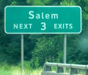 The image is of a roadsign with green background and white lettering that reads: Salem NEXT 3 EXITS.