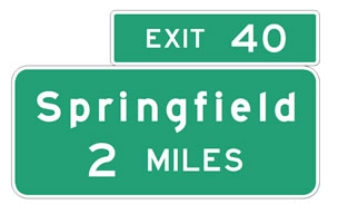 Guide signs in standard alphabet with white lettering and a green background. The top sign reads: Exit 40.  The lower sign reads: Springfield 2 MILES.