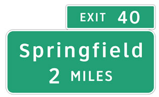 Guide signs in Clearview font with white lettering and a green background. The top sign reads: Exit 40.  The lower sign reads: Springfield 2 MILES.