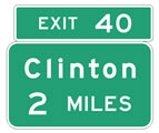 Two road signs on top of each other with green background and white writing.  The signs read: 1) Exit 40, 2) Clinton 2 Miles