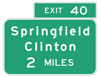 Two road signs on top of each other with green background and white lettering.  The signs read: 1) Exit 40, 2) Springfield Clinton 2 Miles.
