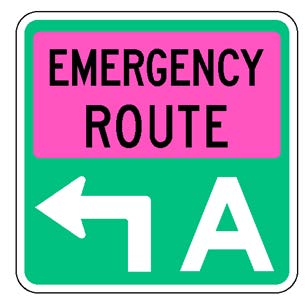 A square single sign with a green background color.  The legend reads "Emergency Route" in black letters within a fluorescent pink rectangular background panel at the top of the sign below which is a white directional arrow that has a white upper-case "A" to its right to identify the route.