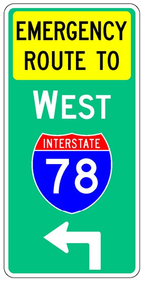 A vertical rectangular single sign with a green background color.  It includes a white directional arrow above which is a full color Interstate route shield above which is a white cardinal direction word legend above which is a yellow rectangular background panel with the words "Emergency Route To" in black letters.