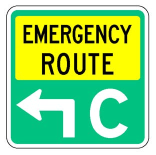 A square single sign with a green background color.  The legend reads "Emergency Route" in black letters within a yellow rectangular background panel at the top of the sign below which is a white directional arrow that has a white upper-case "C" to its right to identify the route.
