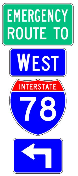 A sign assembly comprised of a white-on-blue directional arrow auxiliary sign above which is a full color Interstate route shield sign above which is a white-on-blue cardinal direction auxiliary sign above which is a supplemental plaque with the legend "Emergency Route To" in white letters on a green background.
