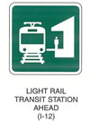 Railroad and Light Rail Transit Grade Crossing Sign "LIGHT RAIL TRANSIT STATION AHEAD (I-12)" is shown as a square green sign with a white border and legend. It shows a symbol of a head-on view of a light rail transit vehicle on a track to the left of a symbol of a person standing on a rail station platform.