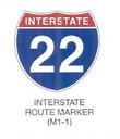 Guide Sign "INTERSTATE ROUTE MARKER (M1-1)" is shown as a cutout shield with a white border. In the top fourth of the shield, the word "INTERSTATE" is shown in white on a red background above a horizontal white line that extends across the width of the sign. Below the line, the large numerals "22" are shown in white on a blue background. The sign is labeled "Interstate Route Sign."