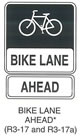 Pedestrian and Bicycle Sign "BIKE LANE AHEAD (R3-17)" is shown as a horizontal rectangular black sign with a white border. A white symbol of a bicycle is shown on the top two-thirds of the sign. A white panel is shown on the bottom third of the sign with the words "BIKE LANE" in black. Below this sign, R3-17a is shown as a horizontal rectangular white sign with a black border and the word "AHEAD" in black. This sign was anticipated for inclusion in the 2003 edition of the MUTCD at the time of this printing.