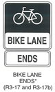 Pedestrian and Bicycle Sign "BIKE LANE ENDS (R3-17)" is shown as a horizontal rectangular black sign with a white border. A white symbol of a bicycle is shown on the top two-thirds of the sign. A white panel is shown on the bottom third of the sign with the words "BIKE LANE" in black. Below this sign,  R3-17b is shown as a horizontal rectangular white sign with a black border and the word "ENDS" in black. This sign was anticipated for inclusion in the 2003 edition of the MUTCD at the time of this printing.