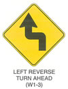 Warning Sign "LEFT REVERSE TURN AHEAD (W1-3)" is shown as a diamond-shaped sign with an upward-pointing arrow with a 90-degree turn to the left and then a 90-degree turn to the right, straightening to a vertical direction.
